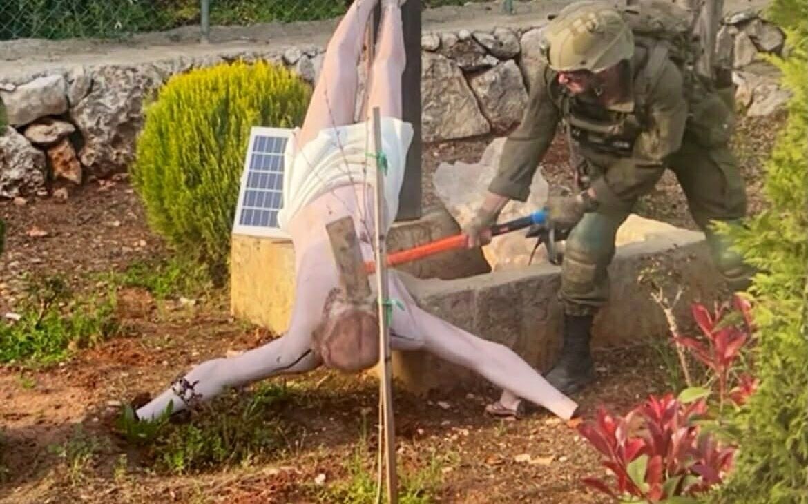 Photo of an Israeli soldier striking a statue of Jesus with a sledgehammer in Debel, Lebanon